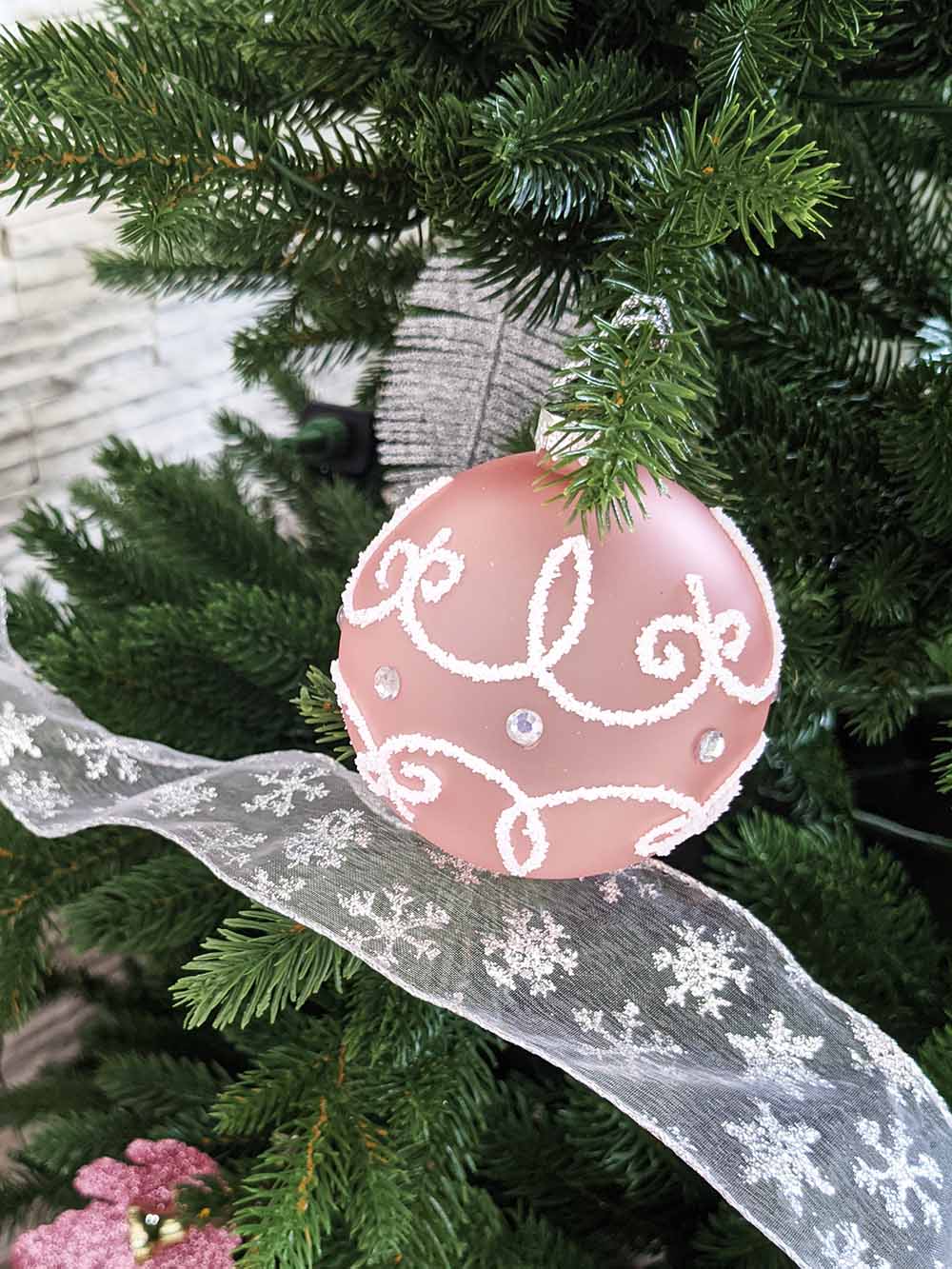 Pink Glass Ball Ornaments with White Decoration on Tree